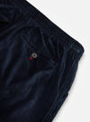 Close-up of the Navy Velveteen Oxford Pant on a white background. Shows the soft, textured material, elastic waistband, and back pocket with button detail.