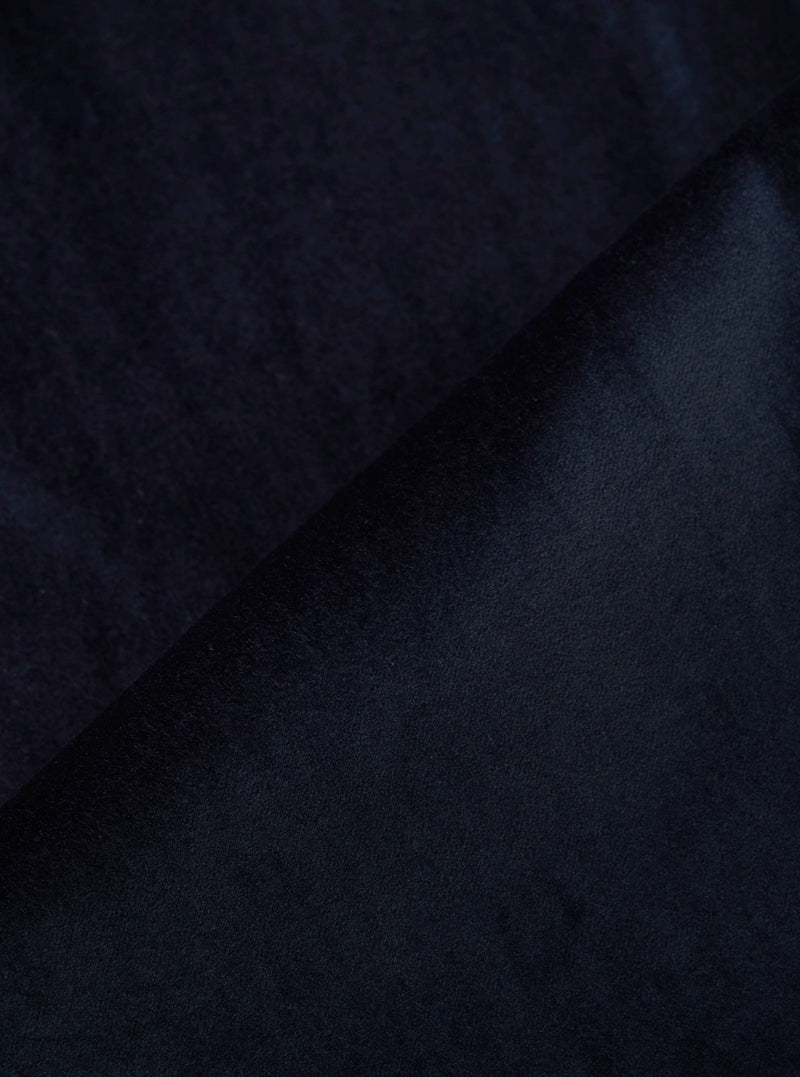 Close-up of the Navy Velveteen Oxford Pant fabric. The rich, dark navy velveteen material is folded, showcasing its soft texture and luxurious sheen.