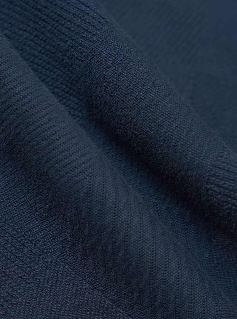 Close-up of the Dark Navy Patchwork Weave Cotton Pleated Track Pant fabric, showing the texture and color. The material is draped to highlight its weave.