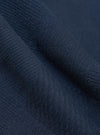 Close-up of the Dark Navy Patchwork Weave Cotton Pleated Track Pant fabric, showing the texture and color. The material is draped to highlight its weave.