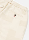 Close-up of the Ecru Patchwork Weave Cotton Pleated Track Pant on a white background. The pants feature a patchwork design and a buttoned pocket.