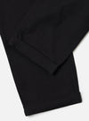 Close-up of the Black Organic Canvas Super Chino pants. The black canvas material is cuffed at the bottom. Shot on a white background.
