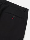 Close-up of the Black Organic Canvas Super Chino showing the back pocket with button detail. The pants are on a white surface.