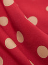 Close-up of the Red Bold Dot Print Rayon Evening Scarf, showcasing its soft texture and vibrant red color with large, light tan polka dots. The fabric is draped to highlight its flow.