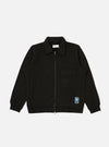 The Black Brush Back Sweat Tyler Sweat Jacket on a white background. The jacket is zipped up and has a pocket on the chest and a logo on the bottom.