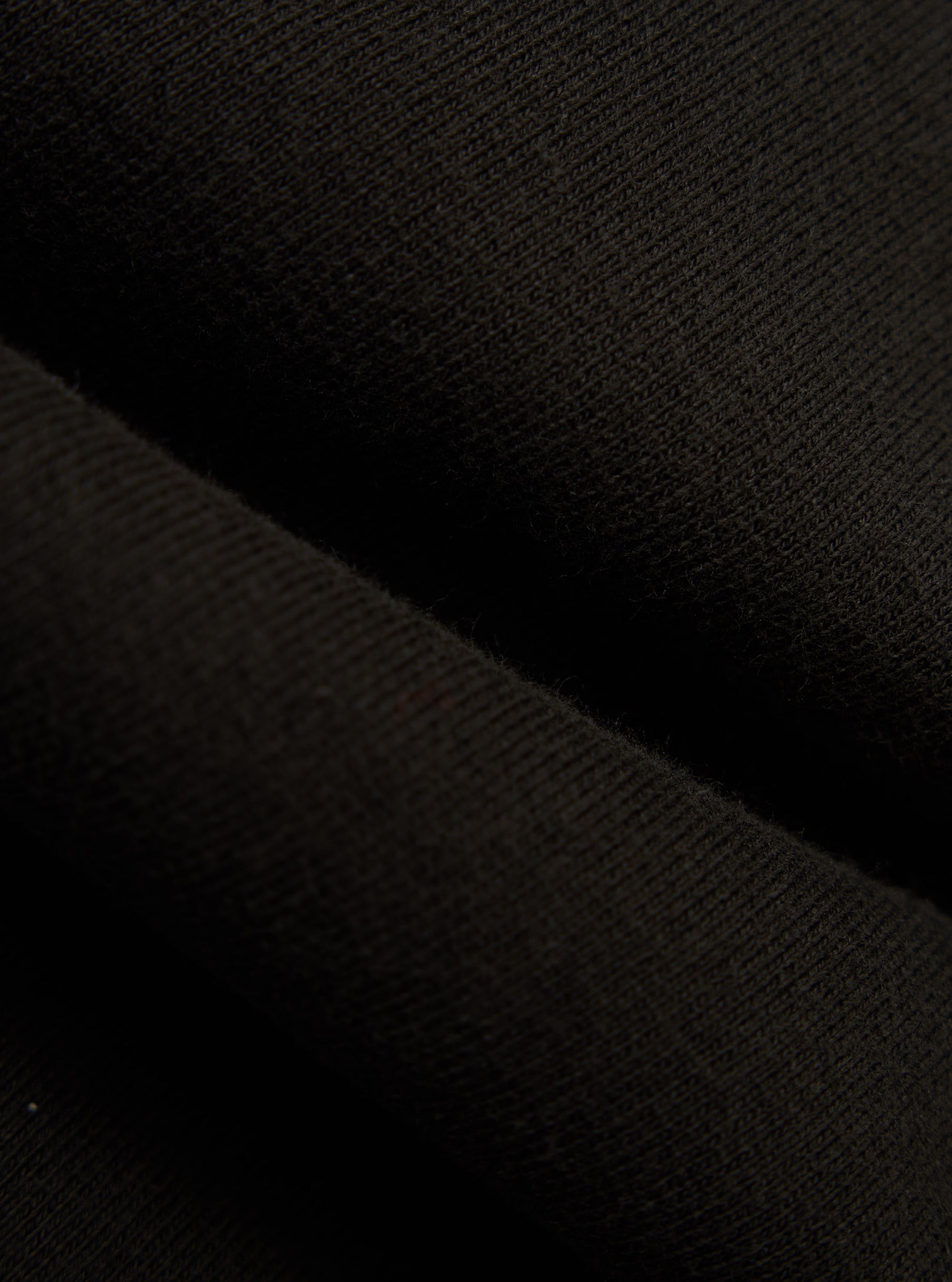 Close-up of the Black Brush Back Sweat Tyler Sweat Jacket fabric. The soft, brushed texture is visible in the dark material.