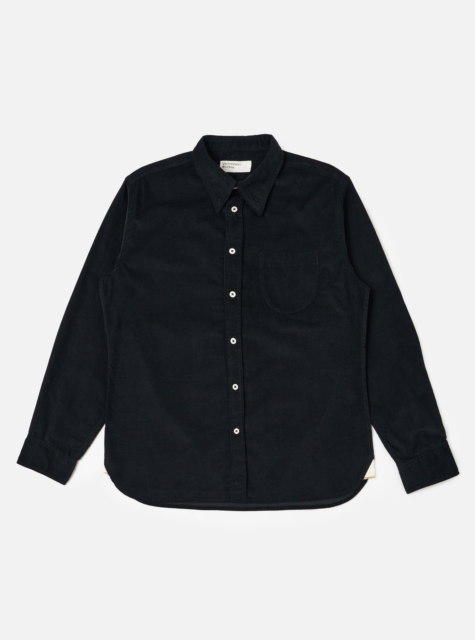 The Black Organic Fine Cord Daybrook Shirt is laid flat on a white background. The shirt is a dark color with long sleeves and a button-up front.