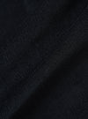 Close-up of the Black Organic Fine Cord Daybrook Shirt fabric. The dark, fine corduroy texture is softly lit, showing the material's depth and quality.