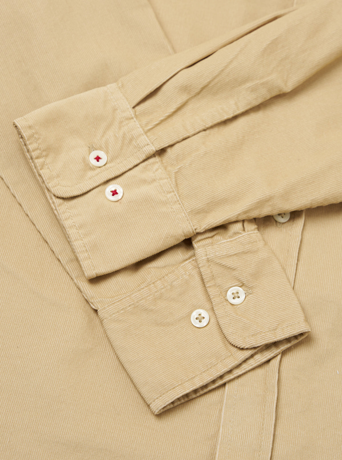 Close-up of the sand-colored Organic Fine Cord Daybrook Shirt, showcasing the fine corduroy texture and button details. The shirt is neatly folded on a neutral surface.