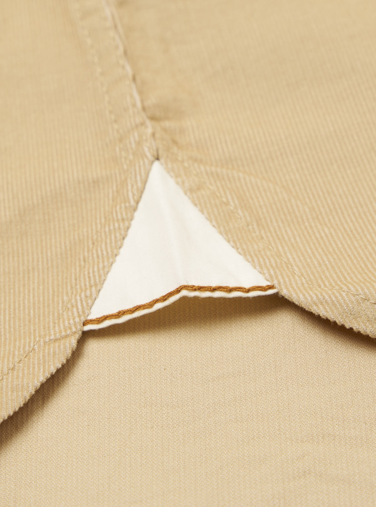 Close-up of the Sand Organic Fine Cord Daybrook Shirt, showcasing the fine corduroy texture and a triangular insert with detailed stitching on a flat, neutral background.