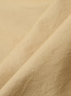 Close-up of the Sand Organic Fine Cord Daybrook Shirt fabric. The fine corduroy texture is visible in a soft, neutral sand color. The fabric is draped to show its texture.