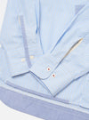 Close-up of the Blue Office Stripe Patched Lazy Day Shirt on a white surface. The shirt features light blue and white stripes, patched details, and buttoned cuffs.