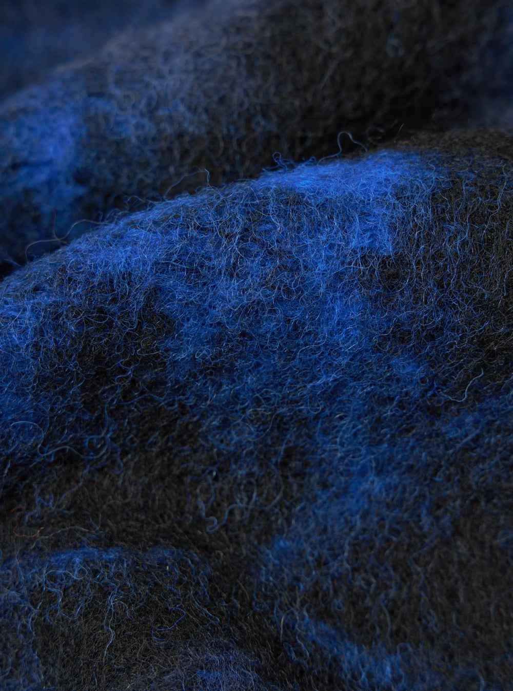 Close-up of the Blue Flower Fleece Zip Liner Jacket material. The fleece is a mix of blue and black fibers, creating a soft, textured look. The background is a simple, neutral surface.