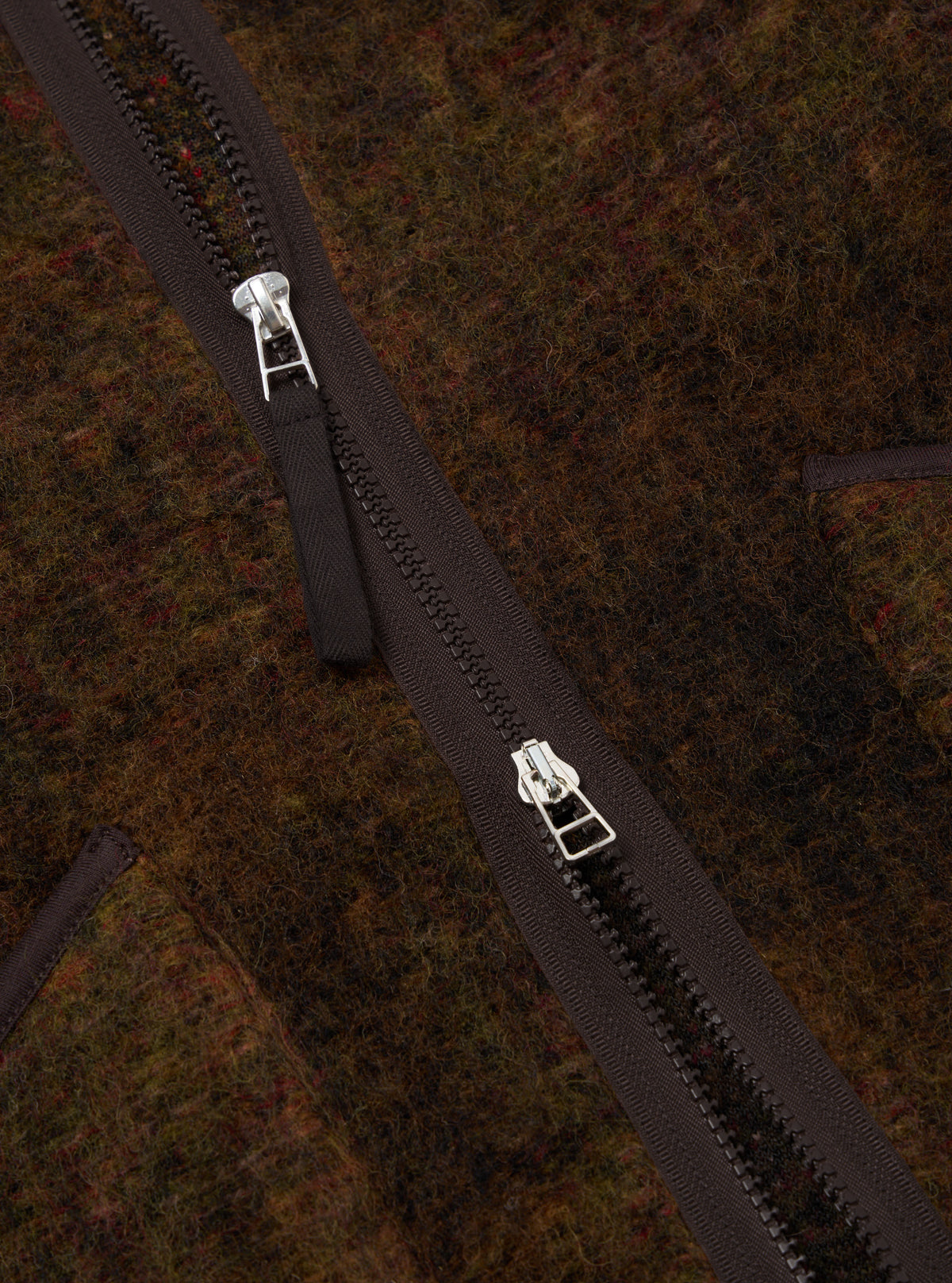 Close-up of the Brown Alps Fleece Zip Liner Jacket showing the texture of the fleece and the zipper detail. The jacket is brown with a dark brown zipper.