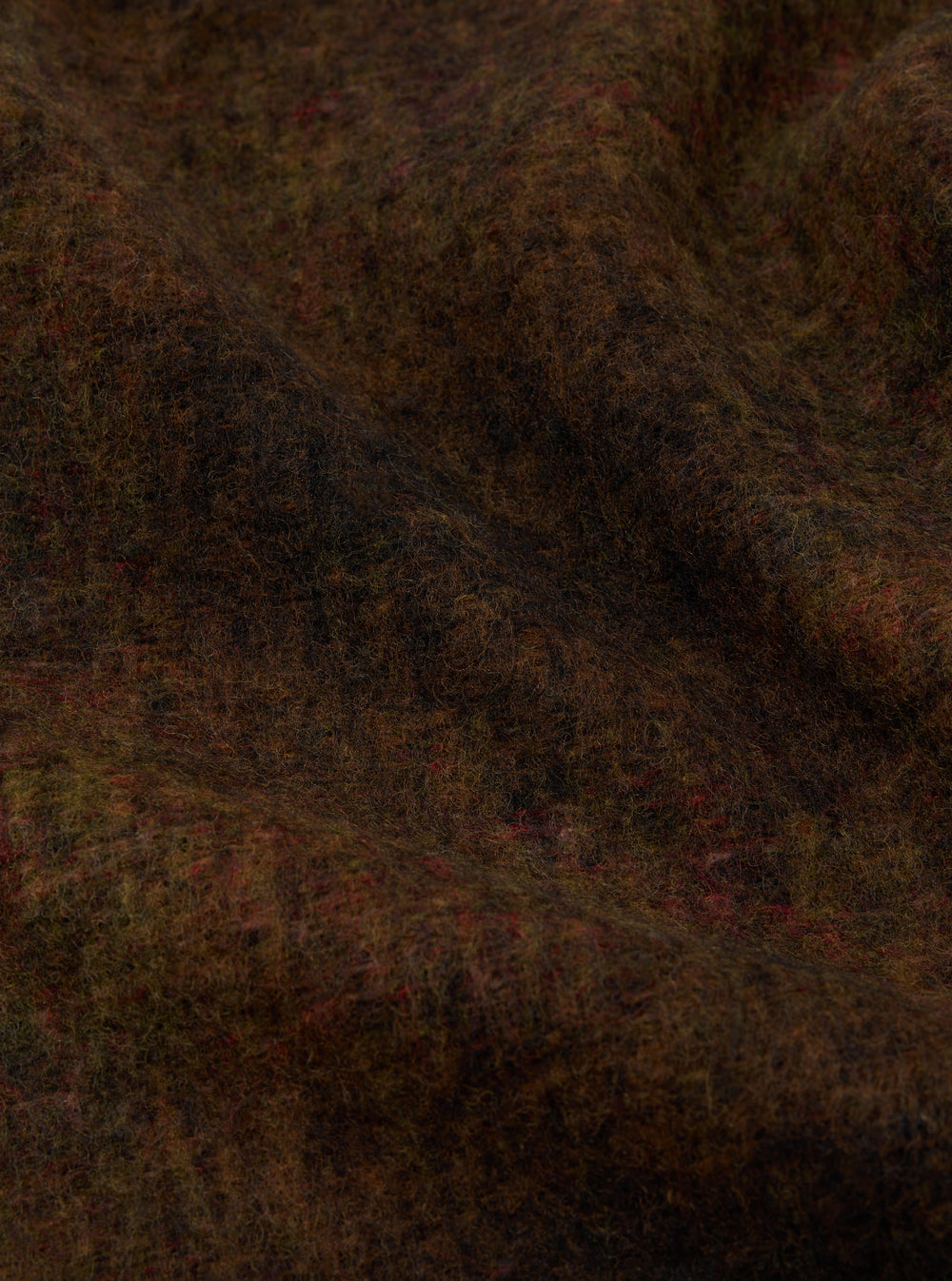 Close-up of the Brown Alps Fleece Zip Liner Jacket material. The brown fleece has hints of red and green. The fabric is draped to show texture.