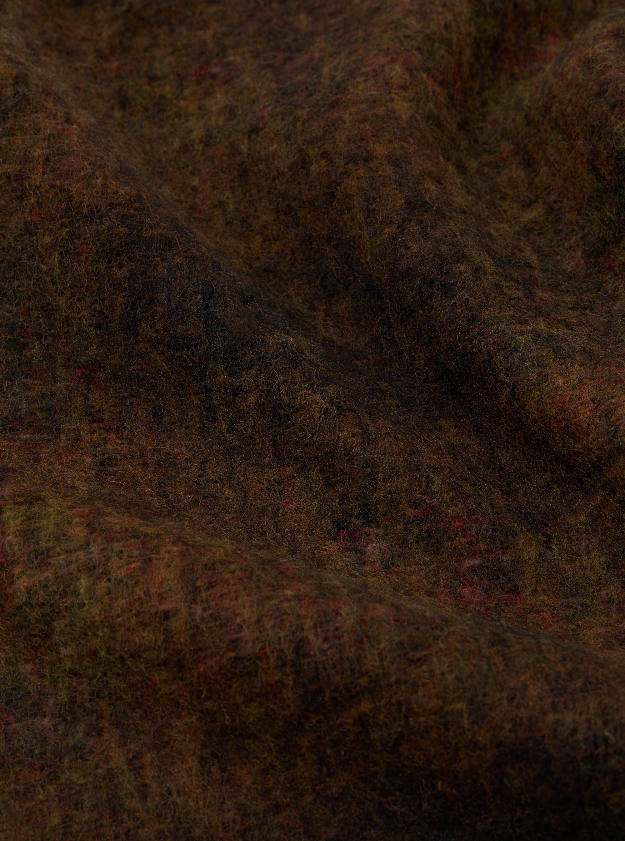 Close-up of the Brown Alps Fleece Zip Liner Jacket material. The brown fleece has hints of red and green. The fabric is draped to show texture.