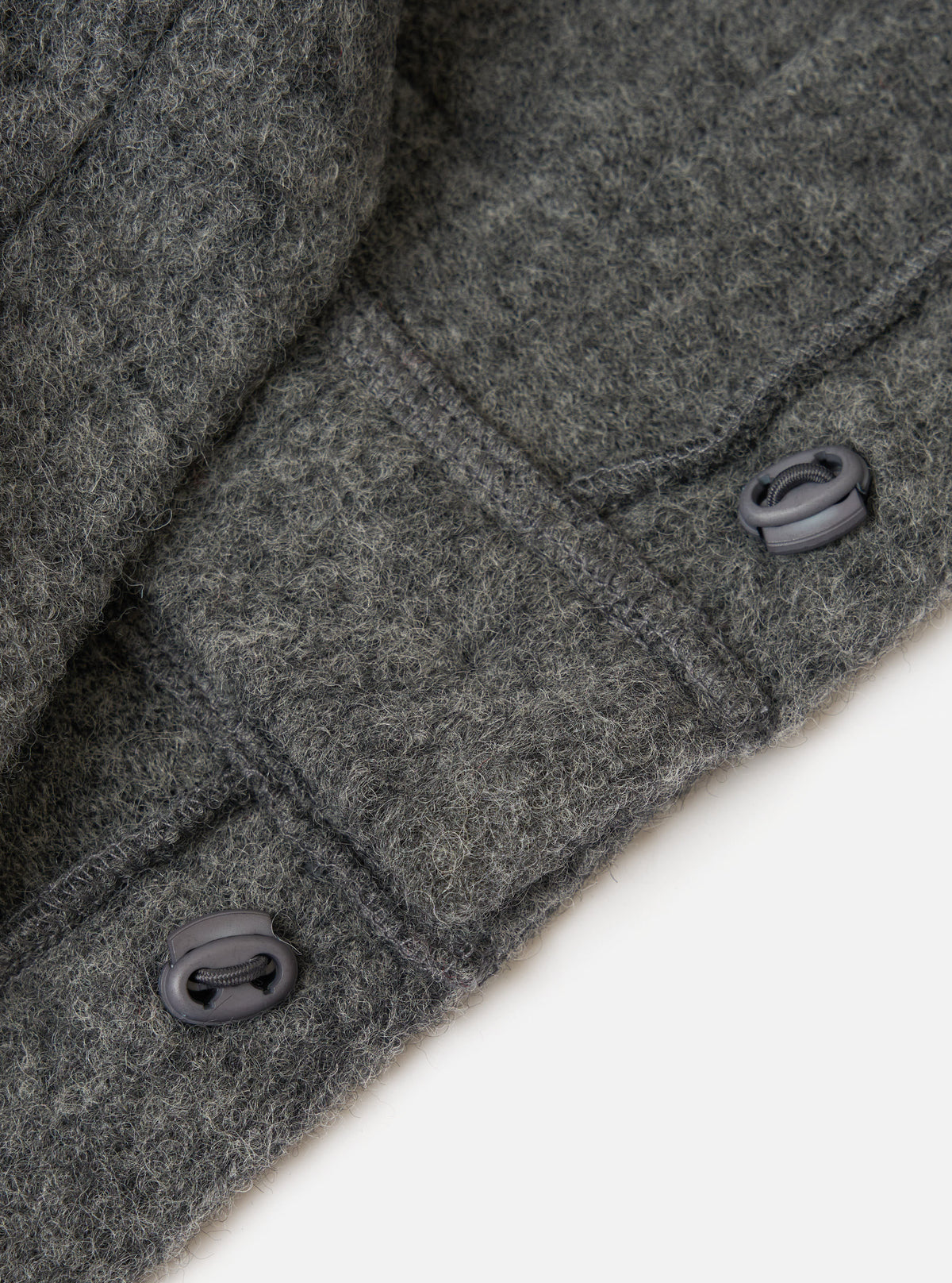 Close up of the Grey Marl Wool Fleece Advance Cardigan showing the wool texture and toggle fastenings against a plain white background.