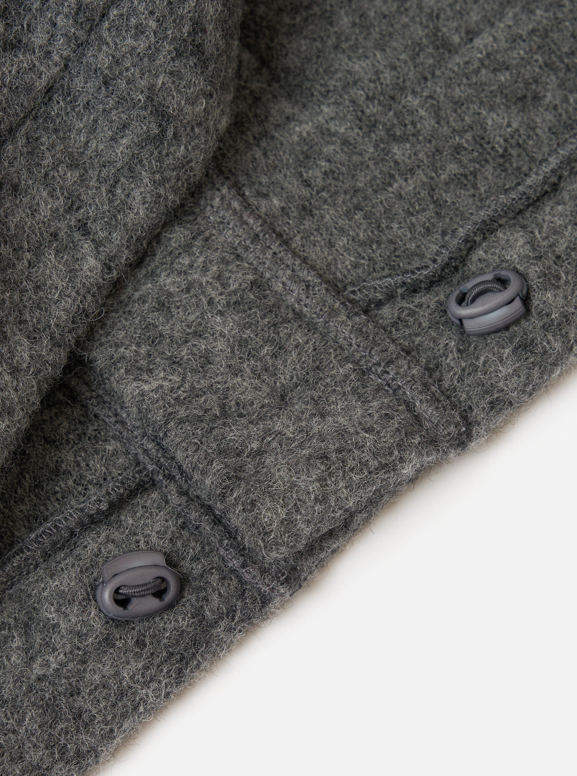 Close up of the Grey Marl Wool Fleece Advance Cardigan showing the wool texture and toggle fastenings against a plain white background.