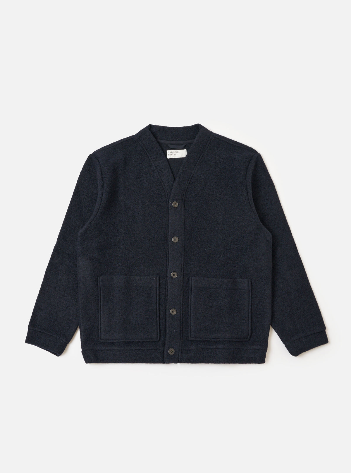 The Navy Wool Fleece Advance Cardigan is displayed on a white background. The cardigan is a dark navy color and made of a soft wool fleece material. It has a relaxed fit and features two front pockets.