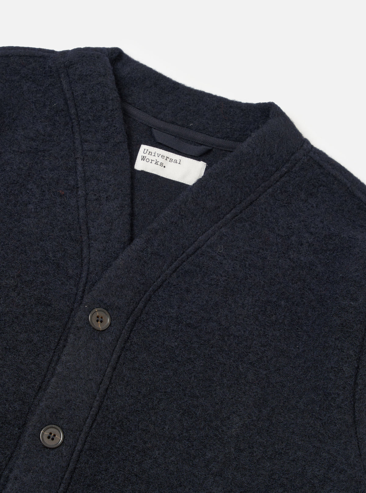 Close-up of the Navy Wool Fleece Advance Cardigan on a white background. Shows the texture of the wool and button details.