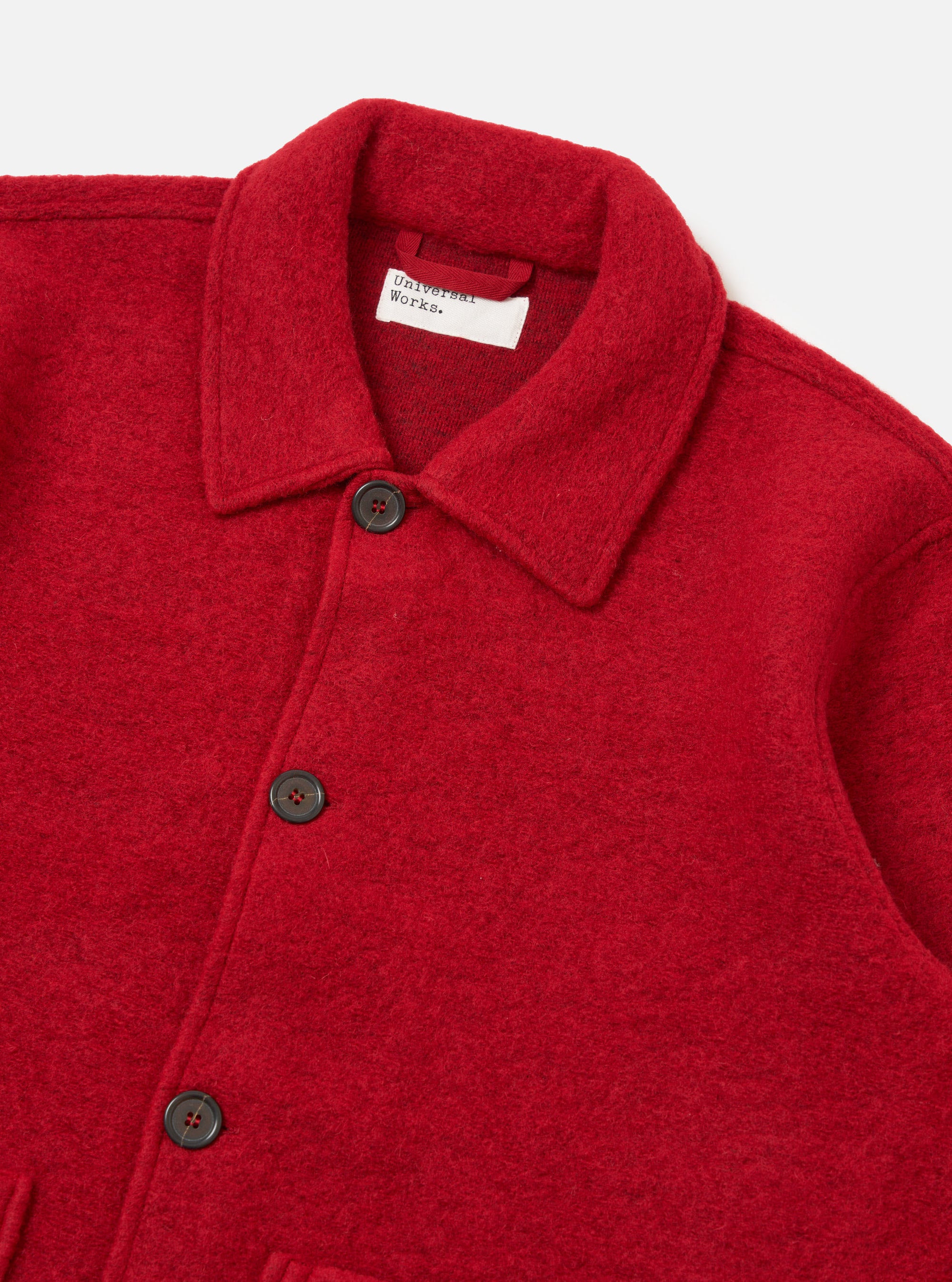 Close-up of the red wool fleece Rams Jacket on a white background. The jacket has a button-up closure and a classic collar.