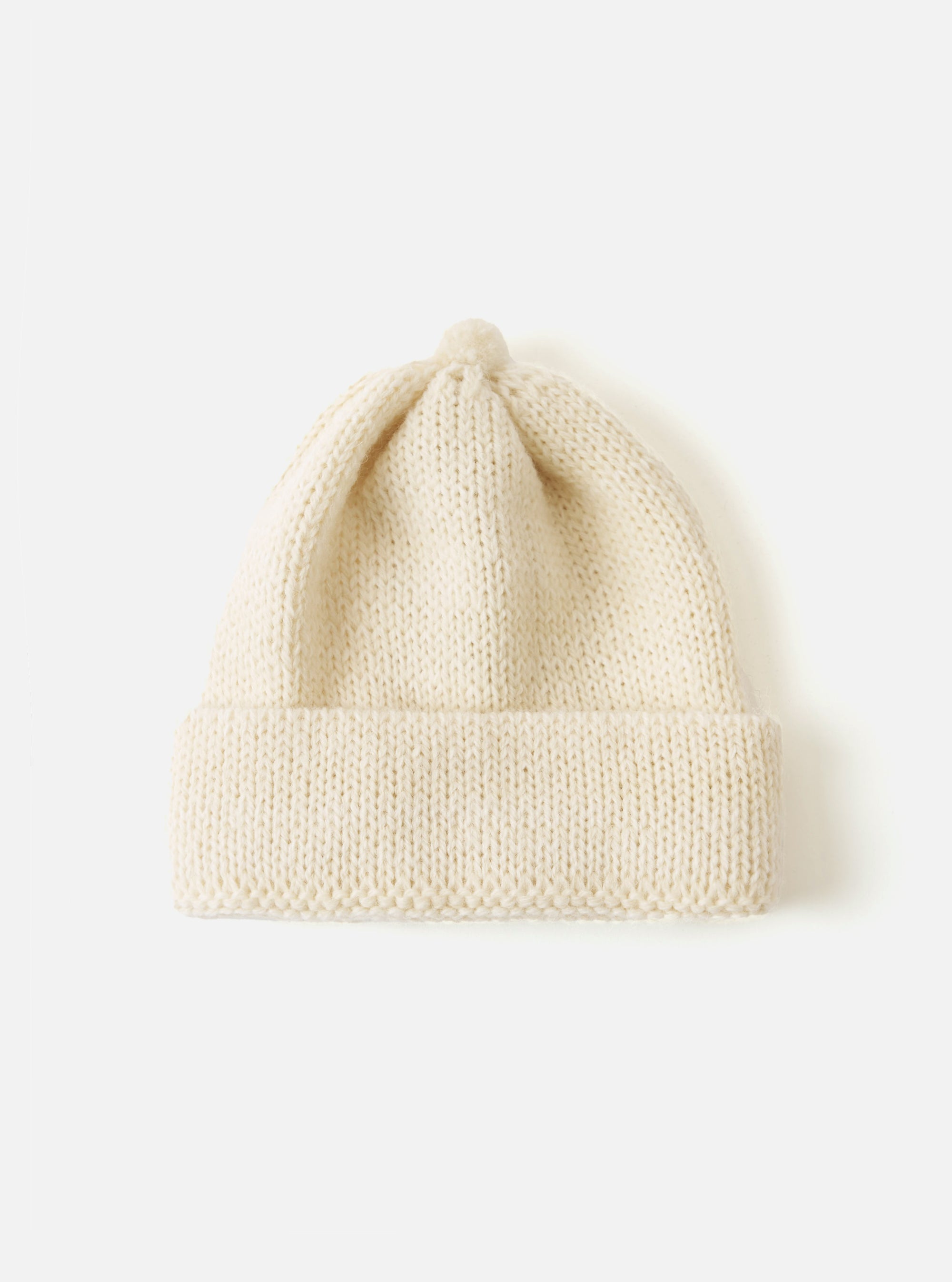 Close-up of an Ecru Alpaca/British Wool Bobble Hat on a white background. The knitted hat is soft and warm, perfect for winter.