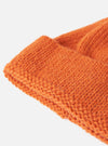 Close up of the Orange Alpaca/British Wool Bobble Hat on a plain white background. The wool is knitted and the hat is folded at the brim.