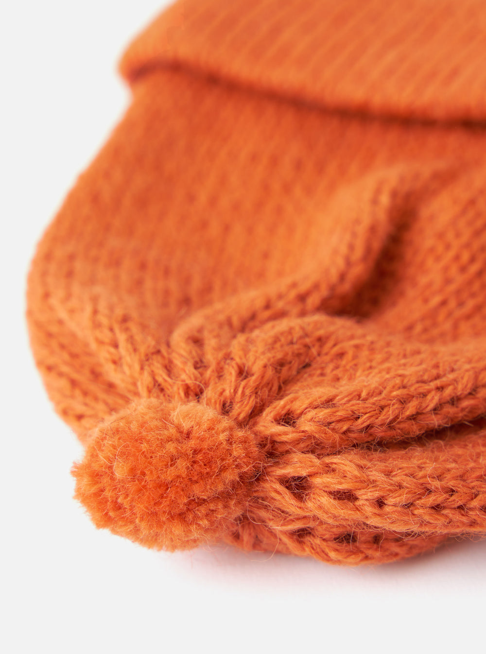 Close-up of an Orange Alpaca/British Wool Bobble Hat on a white background. The knit is chunky and textured, showing the quality of the wool.