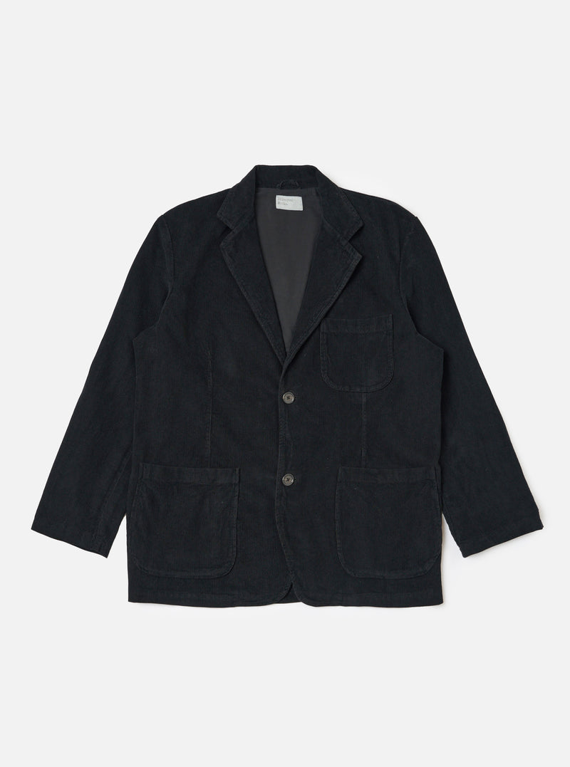 The Black Cat Cord Two Button Jacket in black corduroy, laid flat on a white background. The jacket has two front pockets and a notched lapel.