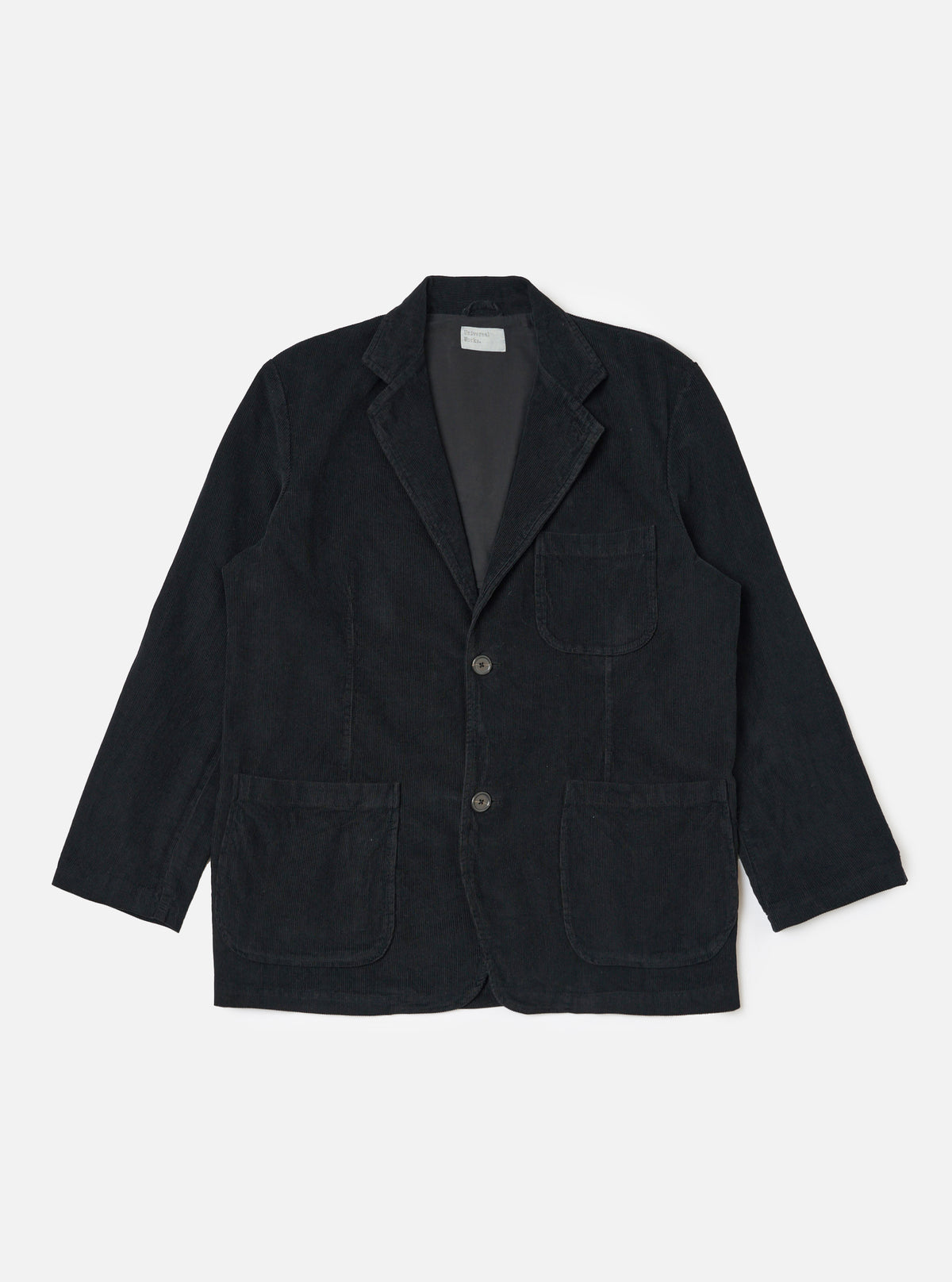 The Black Cat Cord Two Button Jacket in black corduroy, laid flat on a white background. The jacket has two front pockets and a notched lapel.