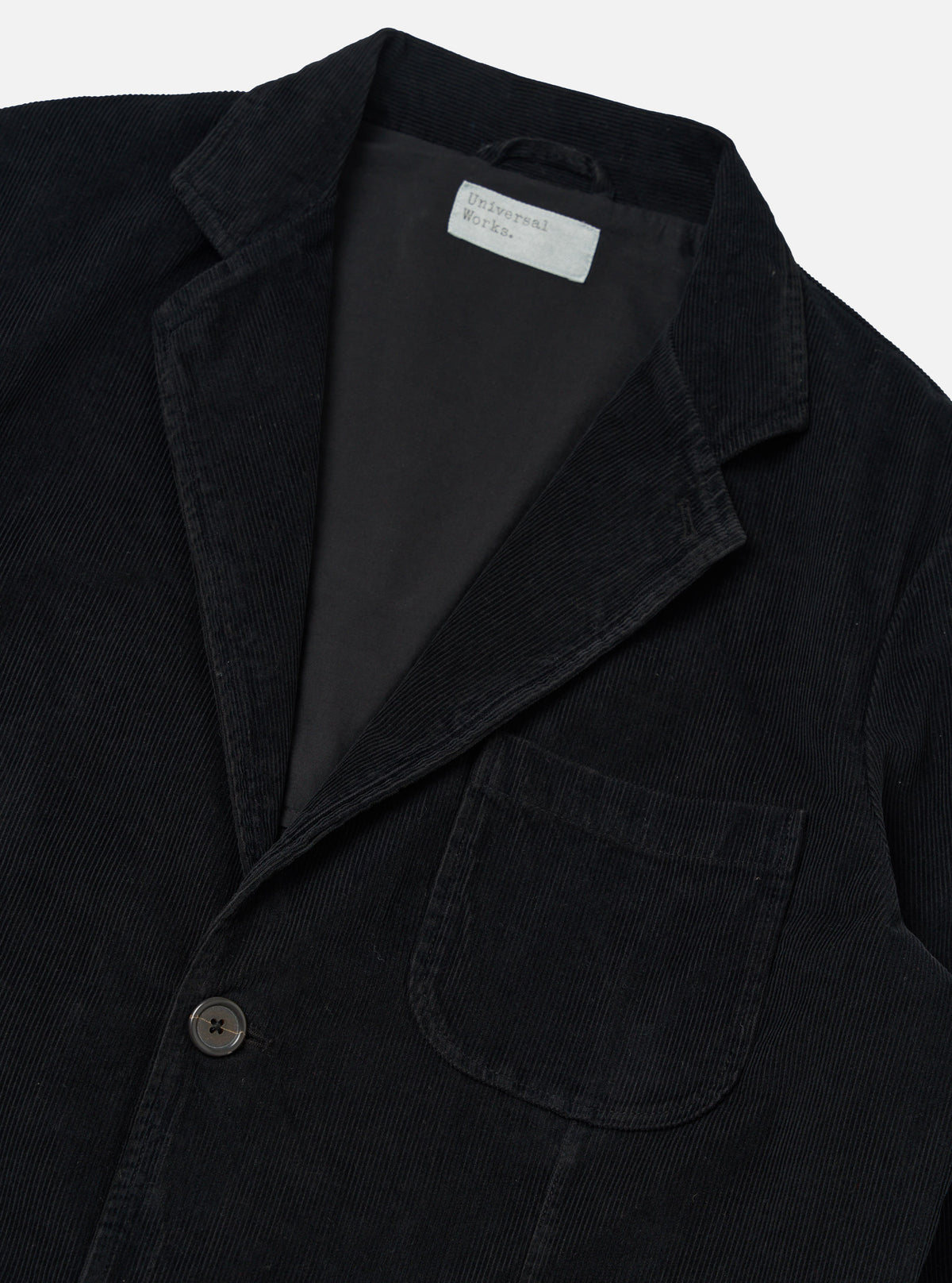Close-up of the Black Cat Cord Two Button Jacket on a white background. The jacket is black corduroy with a two-button closure and a classic fit.