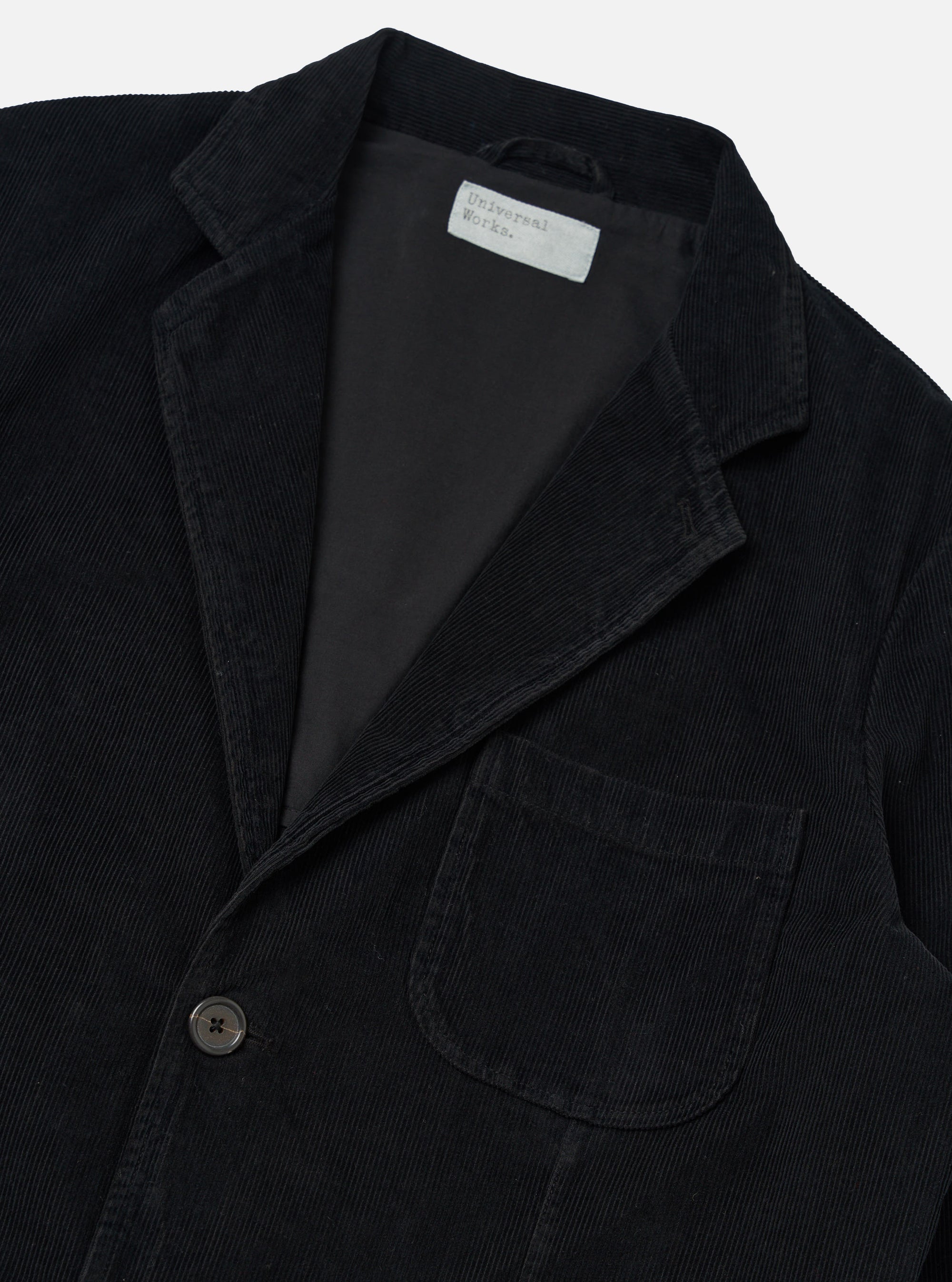 Close-up of the Black Cat Cord Two Button Jacket on a white background. The jacket is black corduroy with a two-button closure and a classic fit.