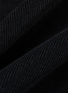 Close-up of the Black Cat Cord Two Button Jacket, showcasing the texture and detail of the black corduroy fabric. The jacket is draped against a dark background.