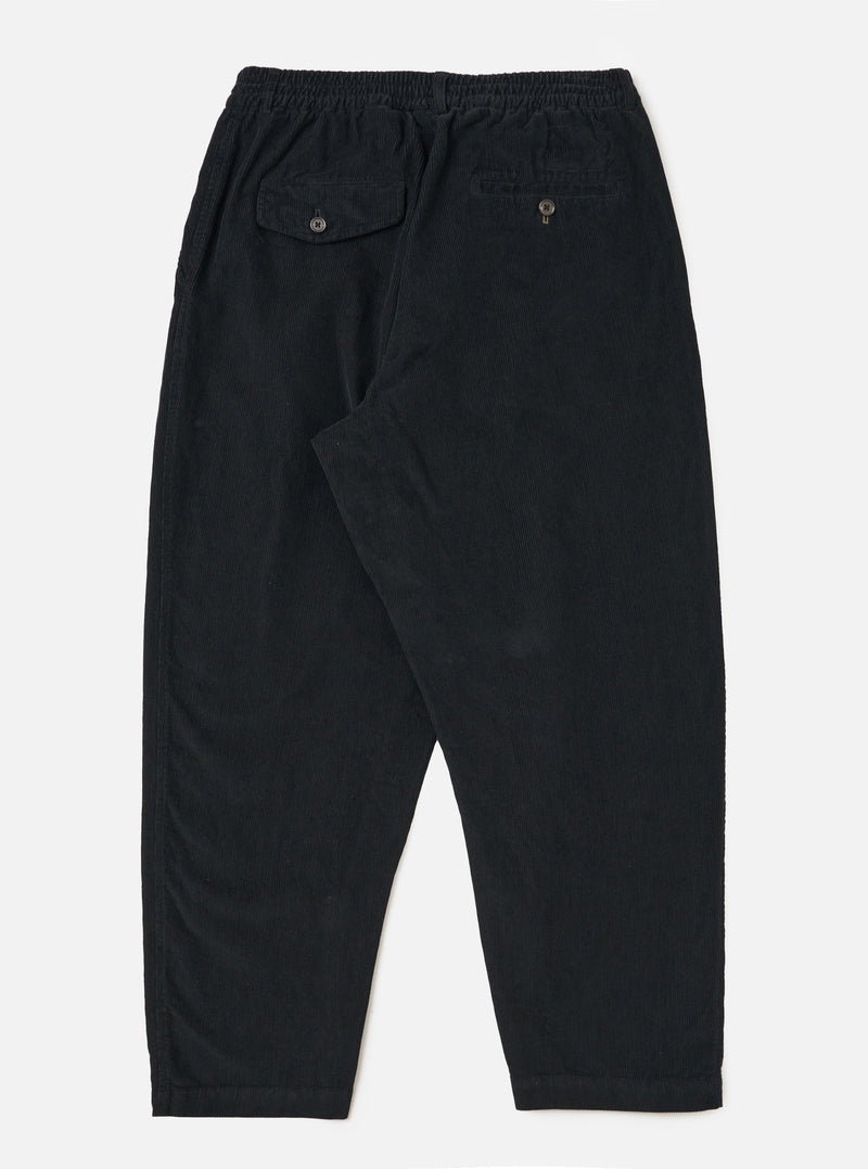 Back view of Black Cat Cord Pleated Track Pant on a white background. Shows the corduroy texture, pleated design, and relaxed fit. Features back pockets with button closures.