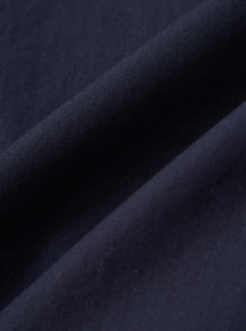 A close-up fabric swatch of the Navy Paper Touch Cotton Vacation Short displays the smooth and crisp texture of the navy blue paper-touch cotton fabric. The image focuses on the fine weave and consistent color of the material.