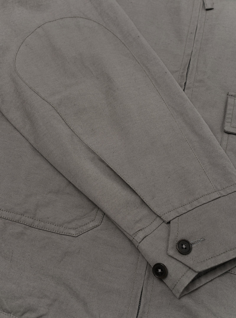 A Mid Grey Linen Slub Weave E130 Jacket is shown from the back, laid flat against a solid white background. The image highlights the straight hem, the simple construction of the back panel, and the textured appearance of the linen-cotton slub fabric.