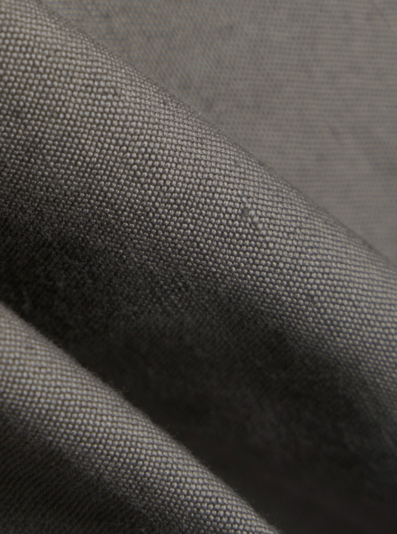 A close-up fabric swatch of the Mid Grey Linen Slub Weave E130 Jacket highlights the textured, slubbed appearance of the linen and cotton blend. The image focuses on the weave and the mid-grey color of the material.