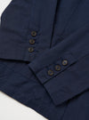 The Navy Linen Slub Weave Manor Jacket is shown from the back as a flat lay against a plain white background. The image highlights the jacket's structured rear with a central vertical seam and a clean, straight hem. The dark navy fabric features a visible slubbed texture from the linen and cotton blend.