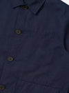 The Navy Linen Slub Weave Franck Jacket is shown in a close-up detail shot against a plain white background. The image focuses on the textured navy blue linen-cotton blend fabric, highlighting the irregular slubbed weave and the clean stitching of a patch pocket and the garment's edge.