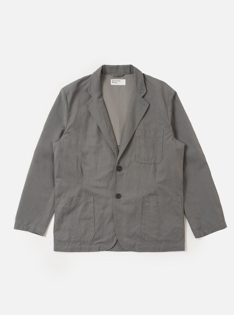 The Mid Grey Linen Slub Weave Two Button Jacket is shown as a flat lay against a white background. The jacket features a notch lapel, a two-button front closure, and two large patch pockets at the waist. The fabric has a visible textured slub weave in a mid-grey tone.