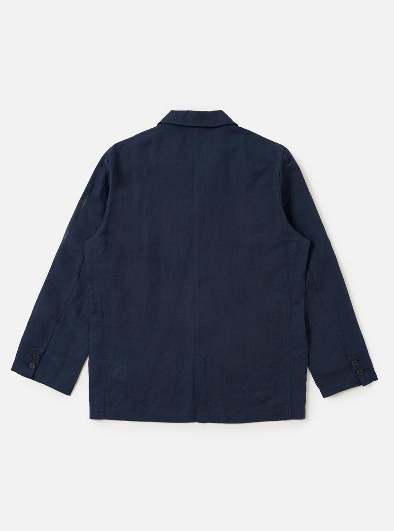The Navy Linen Cotton Shirting Dizzy Jacket is shown from a rear perspective, laid flat against a solid white background. The image highlights the horizontal back yoke, a central vertical seam, and the straight hem of the garment. The textured navy fabric and clean stitching are clearly visible.