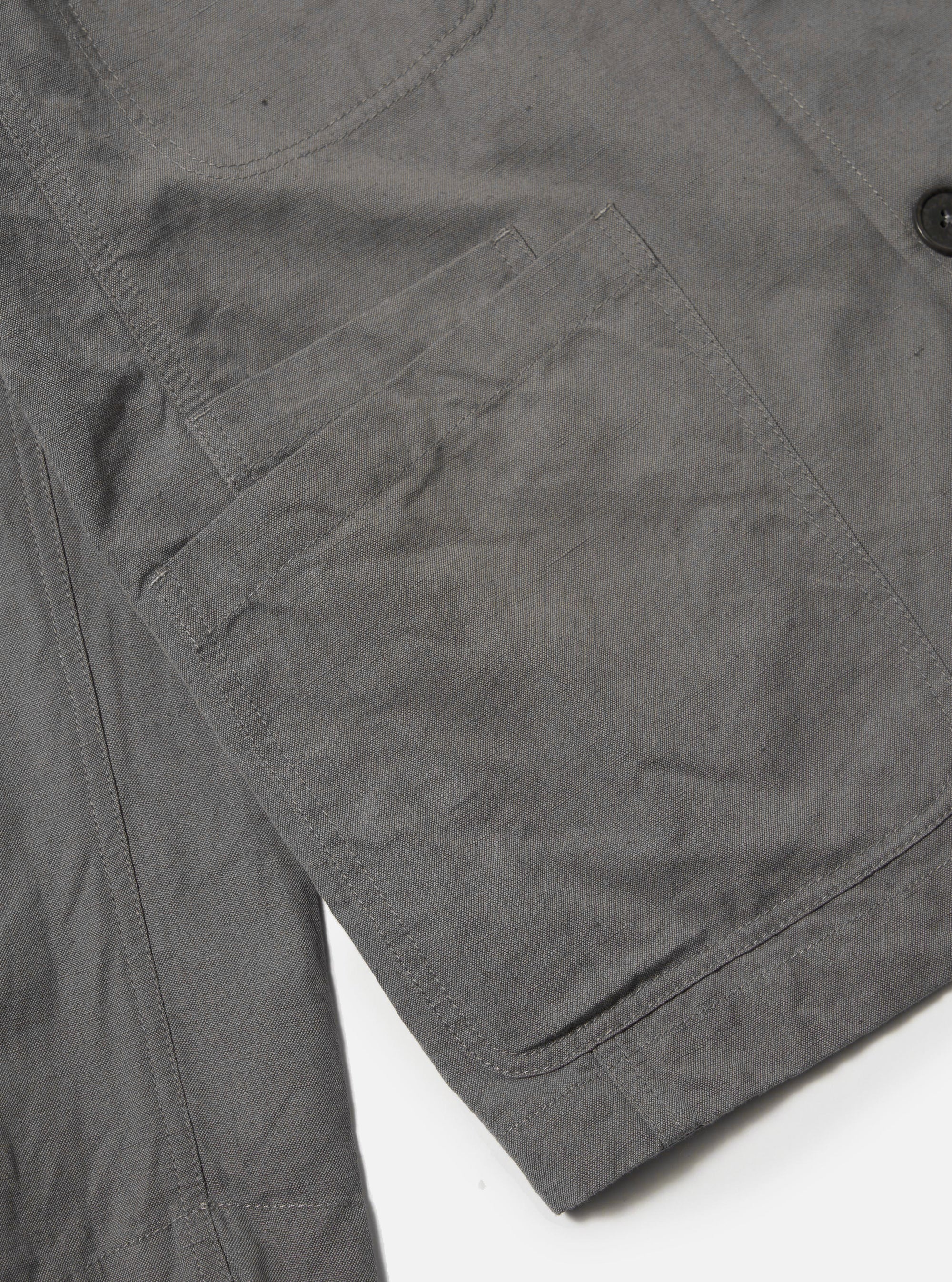 The Mid Grey Linen Slub Weave Bakers Jacket is shown as a flat lay against a white background. The jacket features five front buttons, a single chest patch pocket, and two large lower patch pockets. The fabric has a distinct textured, slubbed appearance.