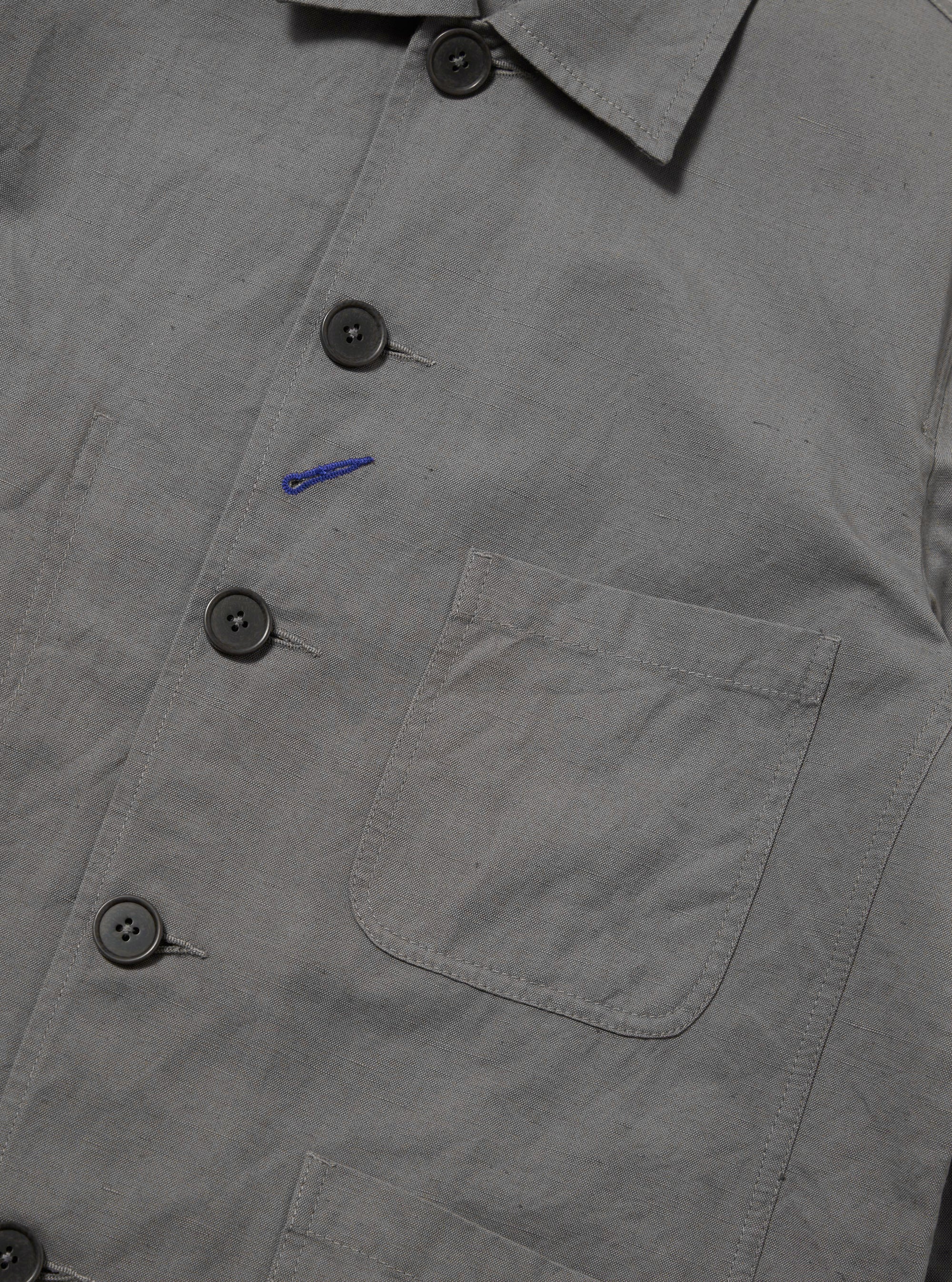 The Mid Grey Linen Slub Weave Bakers Jacket is shown from the back as a flat lay against a white background. The jacket features a straight hem, a center back seam, and a structured collar. The linen-cotton blend fabric has a visible textured slub weave in a mid-grey tone.