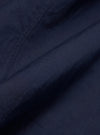 A close-up fabric swatch of the Navy Linen Slub Weave Bakers Jacket highlights the deep navy blue color and the distinct, irregular texture of the linen-cotton blend. The material fills the frame to provide a detailed view of the slubbed weave.