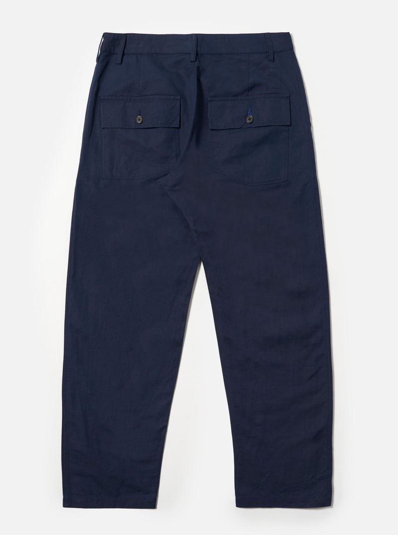 The Navy Linen Slub Weave Dizzy Trouser is shown from the back as a flat lay against a plain white background. The image highlights the two large rear buttoned flap patch pockets and the loose, wide-leg cut. The textured navy blue linen-cotton fabric is the primary focus.