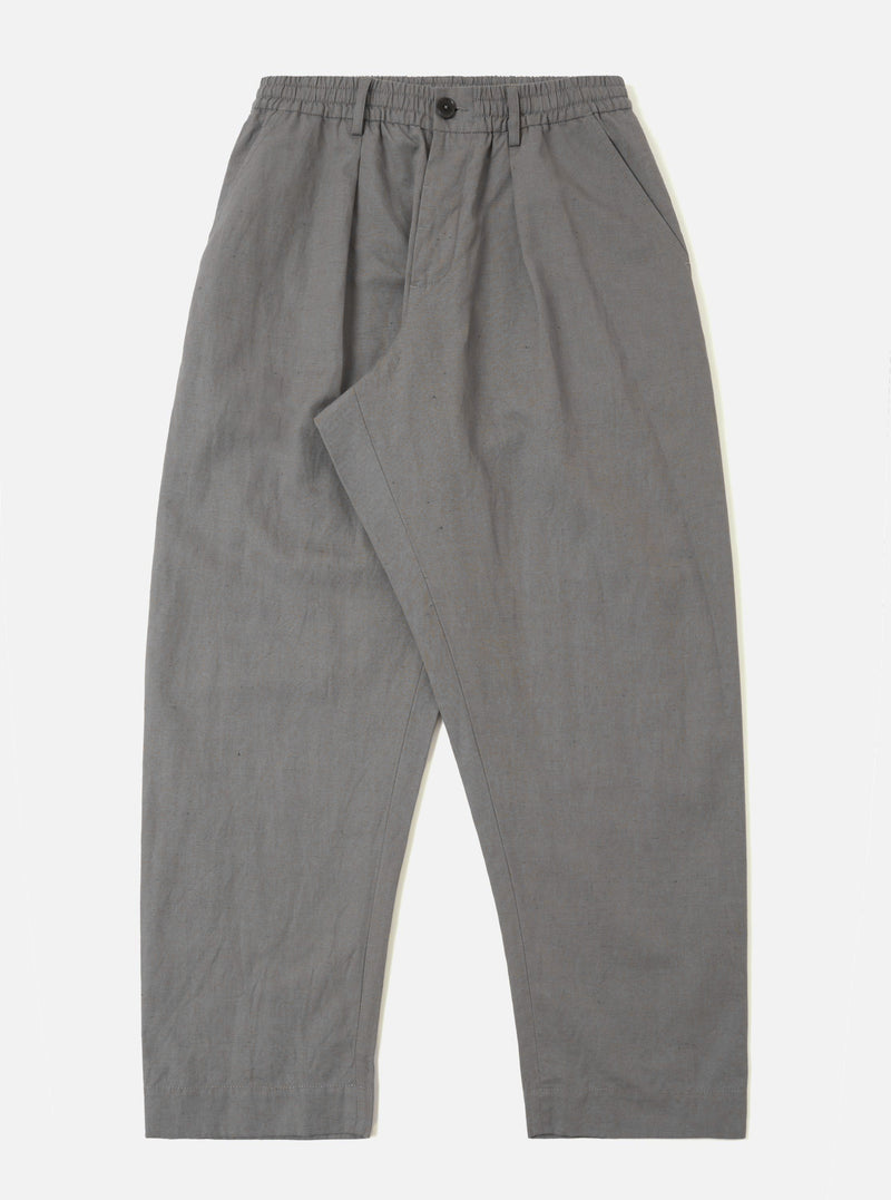 The Mid Grey Linen Slub Weave Oxford Pant is presented as a flat lay against a plain white background. These wide-leg trousers feature an elasticated waistband with a matching grey drawstring, a single pleat on the front, and two side pockets. The mid-grey fabric has a visible slub texture from the linen-cotton blend.