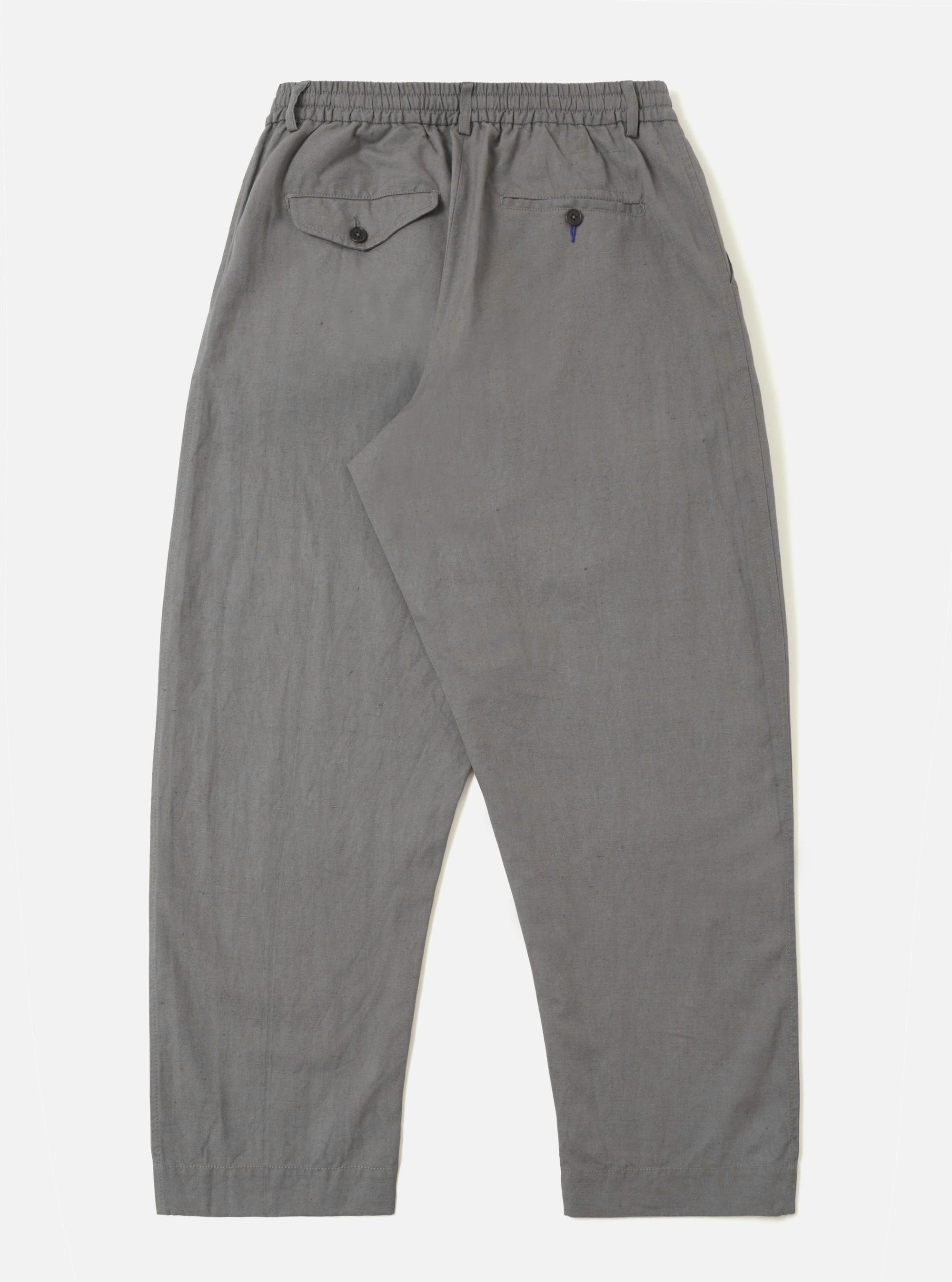 The Mid Grey Linen Slub Weave Oxford Pant is shown from the back as a flat lay against a plain white background. The trousers feature an elasticated waistband and rear patch pockets, highlighting the simple construction of the back. The mid-grey fabric has a distinct slubby texture characteristic of the linen-cotton weave.