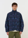Person wearing a blue plaid jacket on a white background