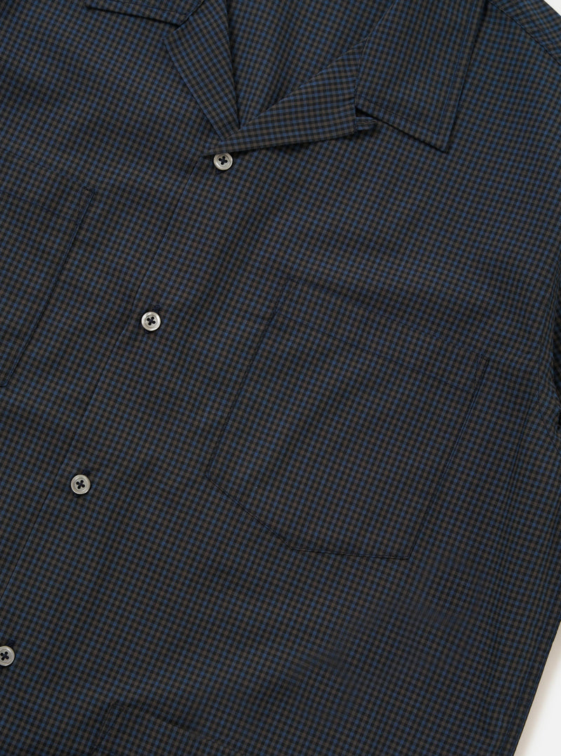 The Navy Check Plaid Summer Overshirt is shown from the back, laid flat against a solid white background. The image highlights the back yoke and the clean, straight hem of the garment, showcasing the dark navy and white plaid pattern.