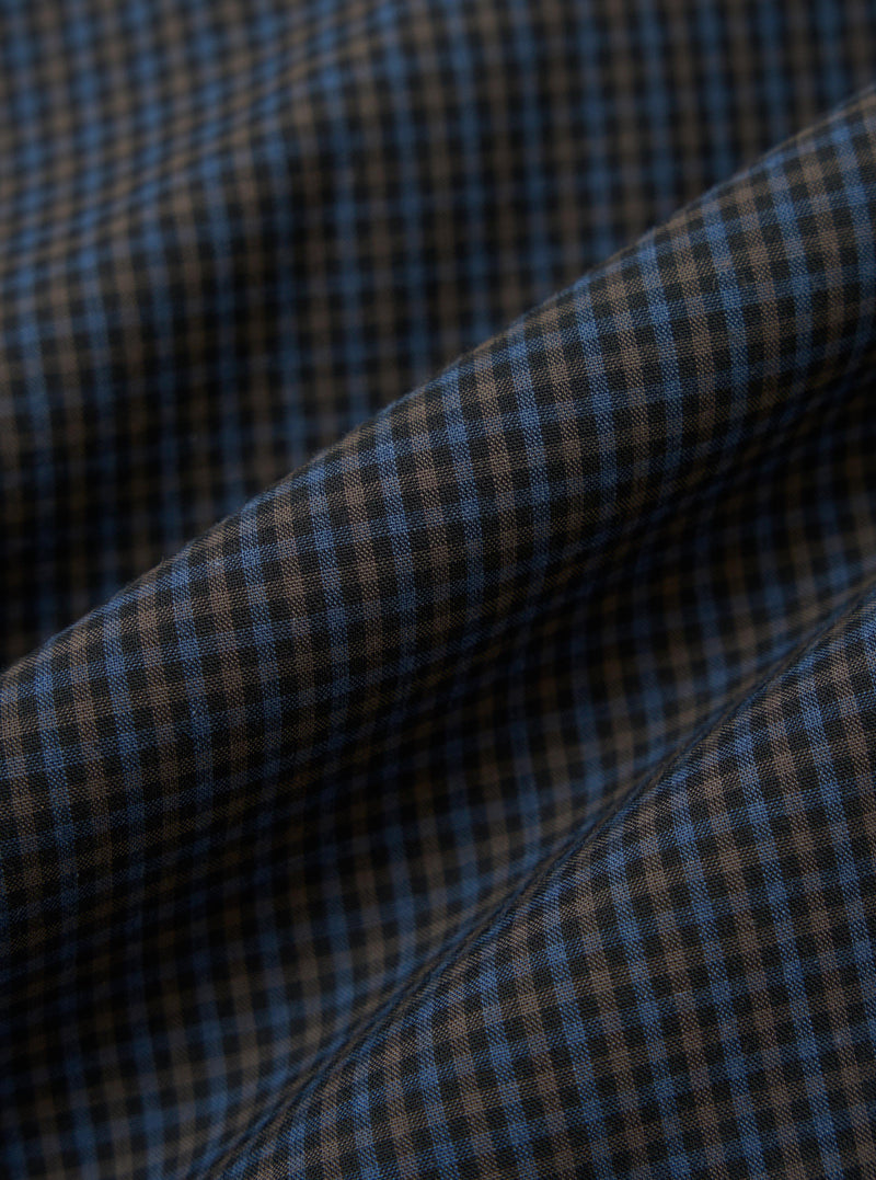 A close-up, square fabric swatch of the Navy Check Plaid Summer Overshirt highlights a detailed plaid pattern. The design features intersecting navy blue and white lines creating a textured, multi-tonal check effect.